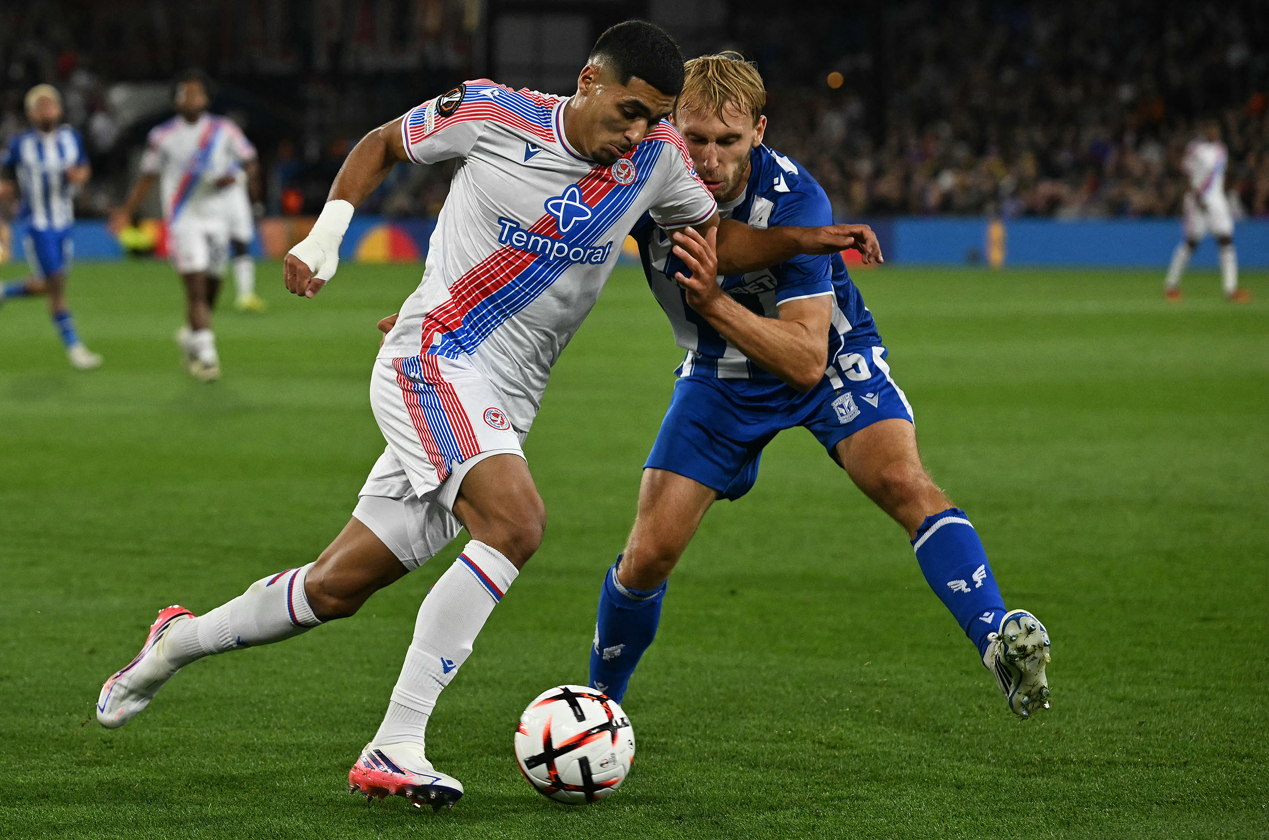 Crystal Palace and Lech Poznan players challenge for the ball during their Europa League match